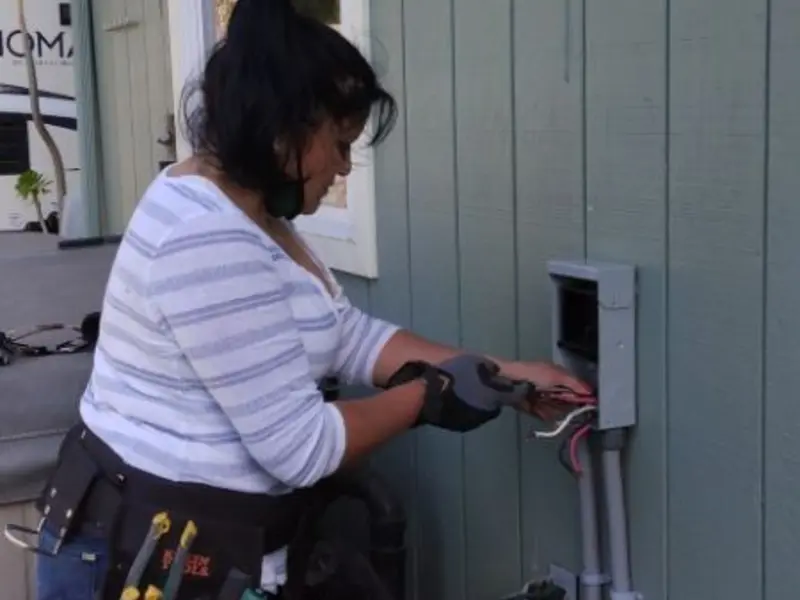 Licensed electrician wiring an exterior subpanel in Clovis